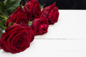 Red roses on white wooden background