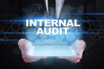 Businessman holding tablet PC with internal audit concept.