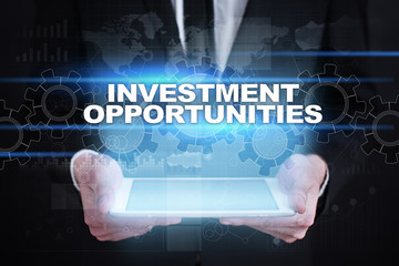 Businessman holding tablet PC with investment opportunities concept.