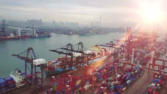 Blurred all visible brand marks. Aerial view of huge industrial port with containers and huge ship.