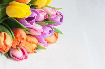 Bright color tulips on the white wooden table