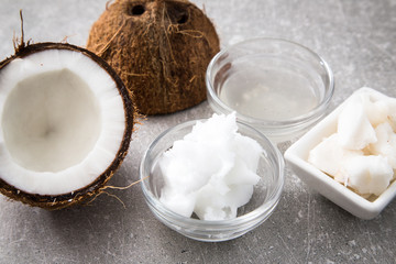 Coconut with coconut oil in jar on wooden background