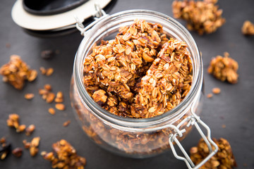 Healthy breakfast. Fresh granola, muesli in a glass jar. copy space.Organic oat,almond and cherry