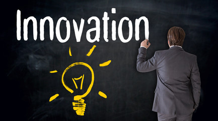 Businessmann malt Glühbirne auf Tafel Konzept