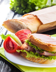 butterbrod with salad tomatoes and dried meat on a white wooden table