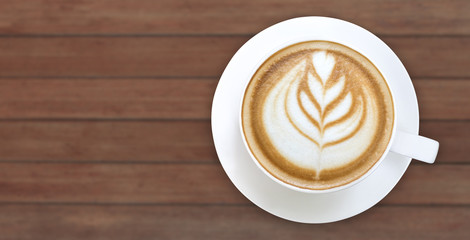 Top view of hot coffee latte art on wood background