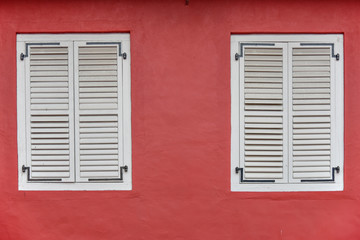 Fototapeta na wymiar White wooden window on red wall