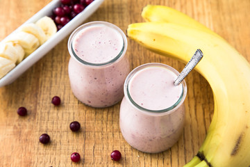 Smoothie of banana and cranberries with yogurt and oats on an old table