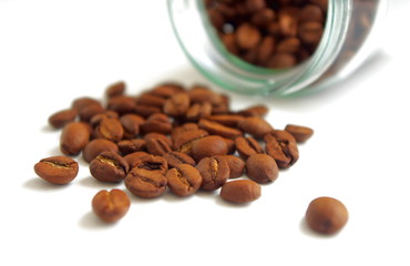 Spilled coffee beans from glass jar