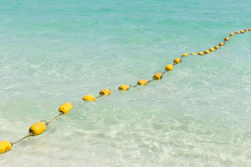 Sea beach with yellow buoys, Safety Swimming zone separator, Thailand ocean travel background.