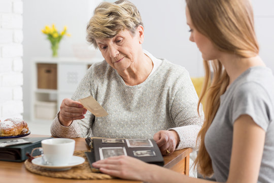 Woman watching photographs with grandmother