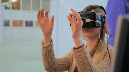 Virtual reality game. Young woman using virtual reality glasses. VR