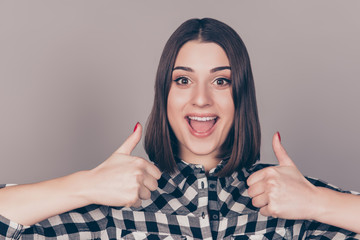 Happy smiling young girl giving thumbs up  isolated on gray background