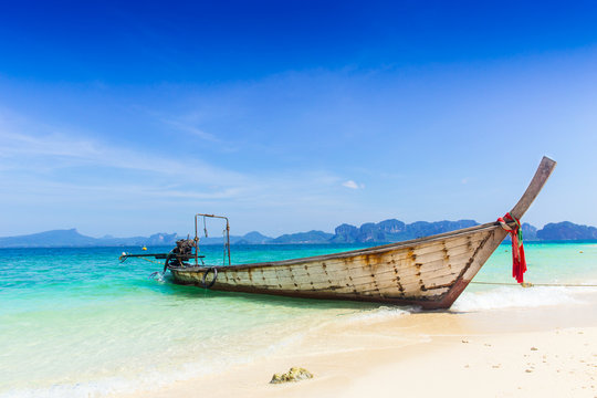 Thailand summer travel sea, Thai old wood boat at sea beach Krabi Phi Phi Island Phuket park on white sand blue sky emerald green ocean water.