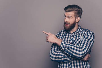 Handsome smiling bearded man showing direction with finger