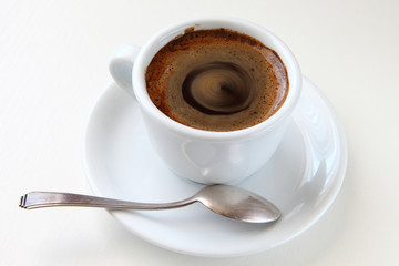 cup of coffee/ cup of black coffee and a teaspoon on a saucer