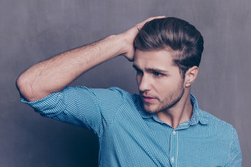 A portrait of young confident handsome man touching his hair