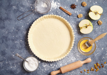 Work with the dough. Form for baking and ingredients for apple pie. The process of preparation of...