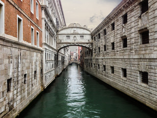 Fototapeta na wymiar The bridge of Sighs in Venice sits over the calm water of a canal