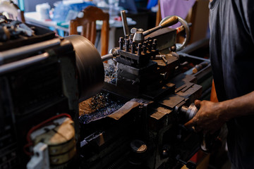 Asians Craftsman being machined steel in a factory