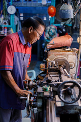 Fototapeta na wymiar Asians Craftsman being machined steel in a factory