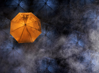 abstract concept of leader with with many dark and a orange umbrella.