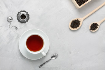 Obraz na płótnie Canvas Cup of tea silver wooden spoons teapot on concrete background.