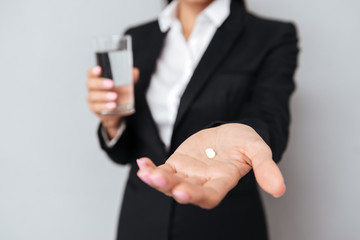Cropped image of Business woman showing pill