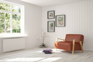 White room with armchair and green landscape in window. Scandinavian interior design