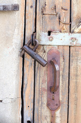 old rusty lock and door handle on a wooden door with paint