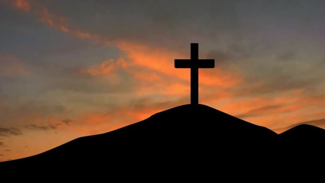 Silhouette of a christian cross on the mountain peak at sunrise time