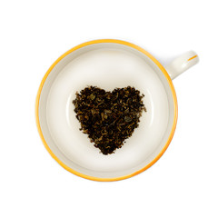 Heart shaped organic black tea in a large white mug isolated on a pure white background.