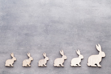 Handmade wood easter rabbits on wooden background.