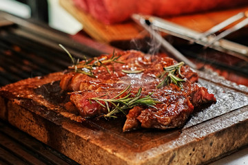 The grilled beef steak on a wooden board.