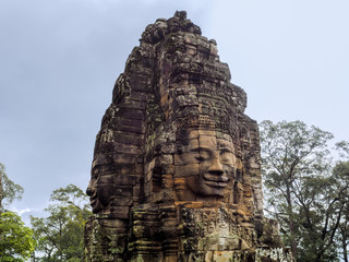Naklejka premium The gigantic face sculptures stone decoration of Bayon Temple in Angkor Thom, the 12th century city of Khmer Empire.