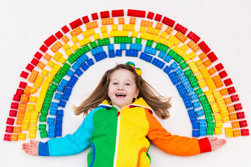 Fototapeta na wymiar Child playing with rainbow plastic blocks toy