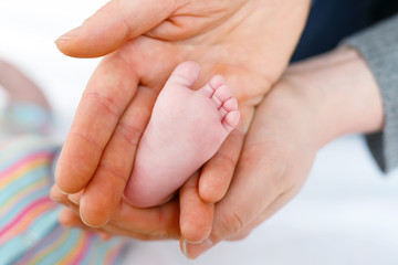 Father or mother holding foot of newborn baby