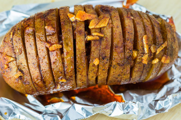 Prepared for oven hasselback potatoes with smoked paprika and bacon.