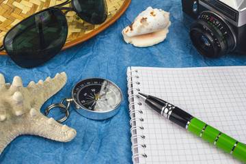 Sea and travel concept with summer holiday accessories, vintage camera, sunglasses, seashells.