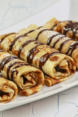 Pancakes with chocolate filling on white background