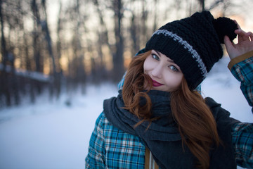 Red-haired girl with make-up in the woods in winter