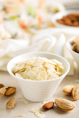 Almond nuts shavings in a bowl on white background, healthy eating