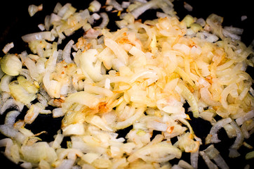 Процесс жарки лука в раскаленной сковороде на растительном масле