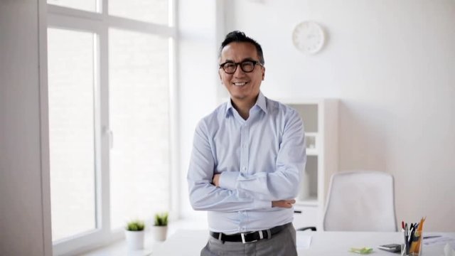 happy smiling asian businessman at office
