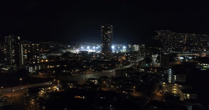 Aerial approach sports stadium at night