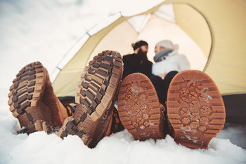 sole of winter shoes. Man and woman in camping tent