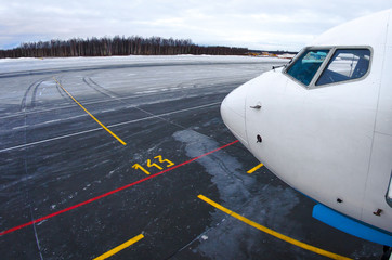 Nose and cockpit of the aircraft, a view of the parking lot and steering track to the runway at the airport