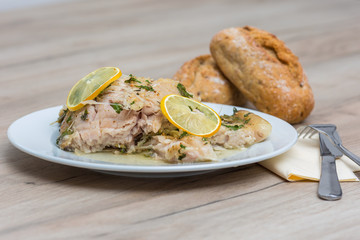 Carp serving on white plate with bread and salad