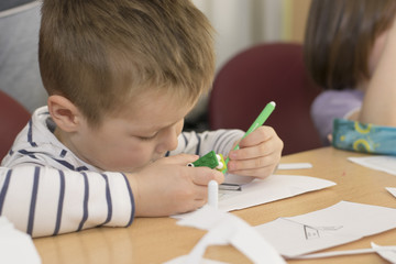 Little blue boy in kindergarten