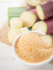 brown sugar and cane on wood background.